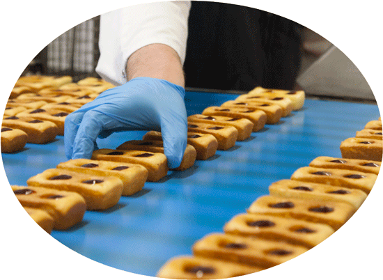 Agence Belle Nouvelle ! Photo d'une ligne de production de gâteaux Brossard avec une main gantée prenant un gâteau