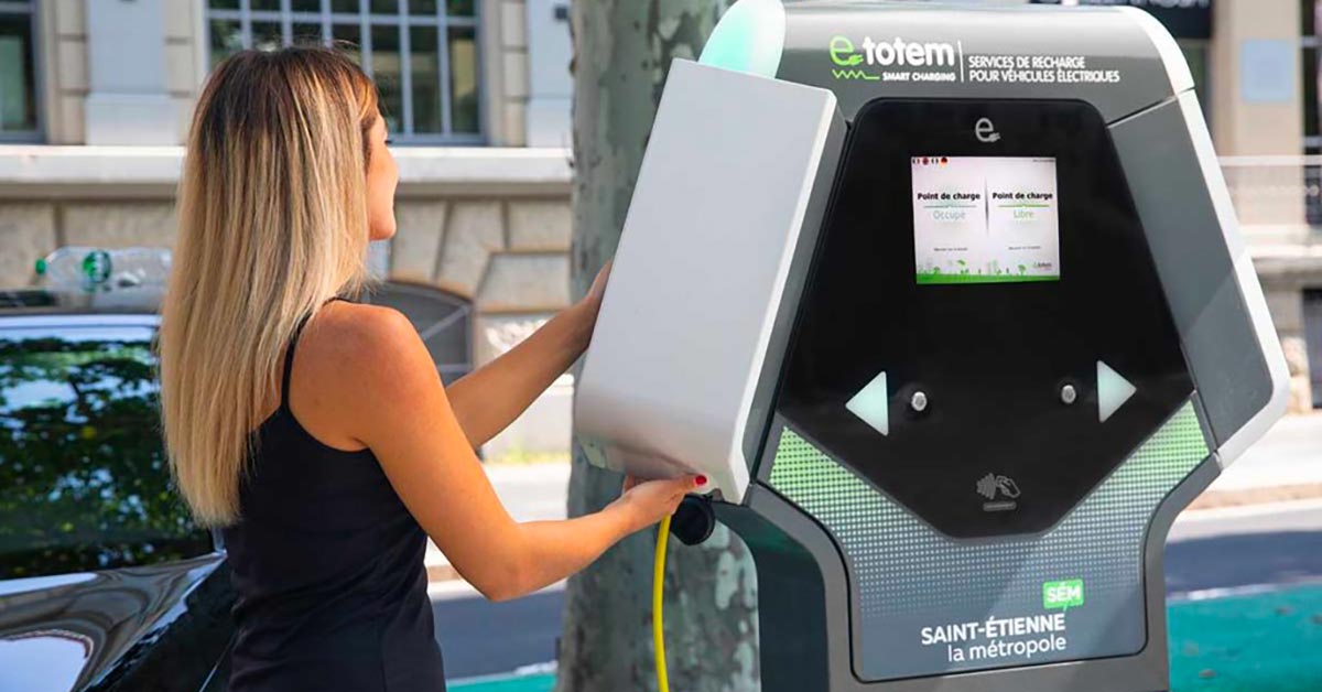 Photo d'une femme devant une borne de recharge électrique E-Totem
